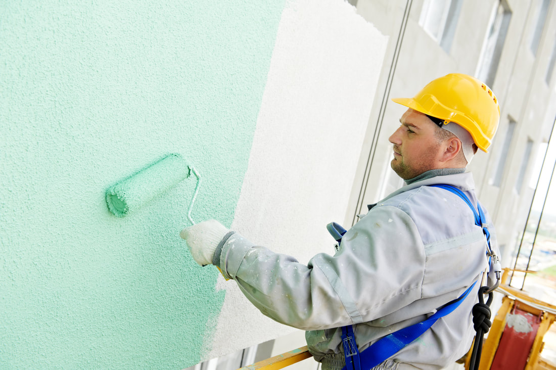 man paints a wall