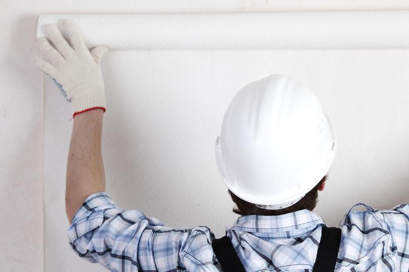 man installing a white wallpaper